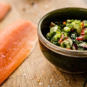 Fresh trout fillets next to a bowl of marinade.