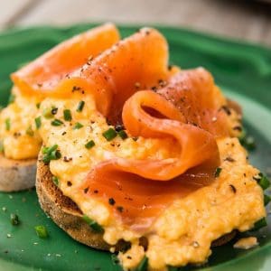 Plate with smoked trout fillet and creamy scrambled eggs.
