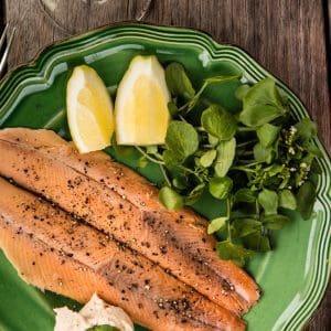 Cooked trout fillets served with fresh watercress.