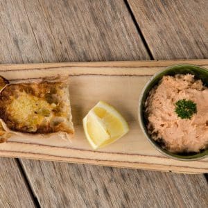 Bowl of trout pâté served with slices of fresh bread.
